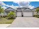 Charming home featuring a paved driveway, manicured lawn, and a two-car garage, under a beautiful, partly cloudy sky at 19912 Bridgetown Loop, Venice, FL 34293