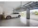 Spacious garage with epoxy flooring, showcasing a white car and ample storage at 19912 Bridgetown Loop, Venice, FL 34293