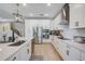 A modern kitchen with white cabinets, stainless steel appliances, and stylish black hardware and light fixtures at 19912 Bridgetown Loop, Venice, FL 34293