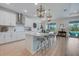 Modern kitchen featuring a center island, white cabinetry, stainless steel appliances, and a dining area at 19912 Bridgetown Loop, Venice, FL 34293