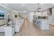 Open-concept living space with a modern kitchen island and sleek, white furnishings at 19912 Bridgetown Loop, Venice, FL 34293