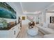 Bright living room featuring a large TV, white furniture, and a wooden console table at 19912 Bridgetown Loop, Venice, FL 34293