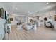 Bright living room featuring open floor plan to kitchen and dining area with hardwood floors at 19912 Bridgetown Loop, Venice, FL 34293