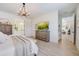 Spacious main bedroom featuring a large bed, wood furniture, and a view into other rooms at 19912 Bridgetown Loop, Venice, FL 34293