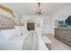 A light and airy main bedroom with a tufted headboard, soft textures, and a view of the en-suite bathroom at 19912 Bridgetown Loop, Venice, FL 34293