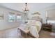 A serene main bedroom featuring natural light, a tufted headboard, and elegant decor at 19912 Bridgetown Loop, Venice, FL 34293