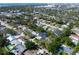 An aerial perspective shows the modern residence set among lush green lawns and trees with views of the distant city at 2177 Sunnyside Pl, Sarasota, FL 34239