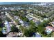 A high angle view shows a modern house with a black roof, green lawns and landscaping in a neighborhood with distant city views at 2177 Sunnyside Pl, Sarasota, FL 34239