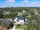 An aerial view of a modern home featuring a dark roof and landscaped yard and partial views of the city in the distance at 2177 Sunnyside Pl, Sarasota, FL 34239