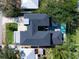 A bird's-eye view shows the layout of the dark roofed home, featuring a pool and outdoor lounge area at 2177 Sunnyside Pl, Sarasota, FL 34239