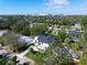 A high angle view reveals a modern home with lush lawns and gardens and a black roof, with distant city views at 2177 Sunnyside Pl, Sarasota, FL 34239
