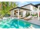 Backyard features include an outdoor kitchen, pool, spa, seating and lush greenery, perfect for entertaining at 2177 Sunnyside Pl, Sarasota, FL 34239