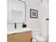 This modern bathroom has neutral paint colors, a wooden vanity, and a glass enclosed shower at 2177 Sunnyside Pl, Sarasota, FL 34239