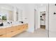 Modern bathroom features double sink, blonde wood vanity, and open walk-in closet at 2177 Sunnyside Pl, Sarasota, FL 34239