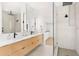 Bathroom featuring double sinks and a frameless glass shower with a rainfall shower head at 2177 Sunnyside Pl, Sarasota, FL 34239