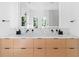 Bathroom with double vanity with marble counters and blonde wood drawers at 2177 Sunnyside Pl, Sarasota, FL 34239