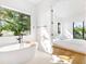 Stylish bathroom and bedroom view featuring a modern soaking tub and an open doorway at 2177 Sunnyside Pl, Sarasota, FL 34239
