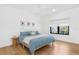 Bright bedroom with a ceiling fan, hardwood floors, a side table and a large window at 2177 Sunnyside Pl, Sarasota, FL 34239
