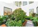 Lush courtyard garden featuring flowering trees, stone paving, and surrounding architecture at 2177 Sunnyside Pl, Sarasota, FL 34239