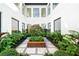 Tranquil courtyard featuring a lush garden centerpiece and elegant stone paving at 2177 Sunnyside Pl, Sarasota, FL 34239