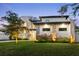 Modern home with a manicured lawn and stone accents, illuminated at twilight at 2177 Sunnyside Pl, Sarasota, FL 34239