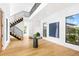 Bright foyer with hardwood floors, an open staircase, and modern artwork at 2177 Sunnyside Pl, Sarasota, FL 34239
