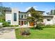 Two-story home featuring modern architecture, manicured lawn, and an orange front door at 2177 Sunnyside Pl, Sarasota, FL 34239