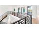 This bright and airy hallway features modern windows, hardwood floors, and black metal railings at 2177 Sunnyside Pl, Sarasota, FL 34239