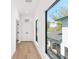 Hallway features light hardwood flooring, modern doors and windows, and lots of natural light at 2177 Sunnyside Pl, Sarasota, FL 34239