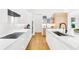 Modern kitchen with white cabinets, white countertops, stainless steel appliances, and light wood floors at 2177 Sunnyside Pl, Sarasota, FL 34239