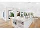 Bright kitchen features a marble island, stainless steel appliances, light wood floors, and lots of natural light at 2177 Sunnyside Pl, Sarasota, FL 34239