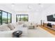 Bright living room with a sectional sofa, entertainment center, and large windows showcasing the backyard at 2177 Sunnyside Pl, Sarasota, FL 34239