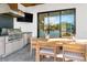 The outdoor kitchen features a built-in grill, stainless steel fridge, bar seating, and seamless indoor-outdoor access at 2177 Sunnyside Pl, Sarasota, FL 34239