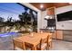 Beautiful outdoor kitchen and dining area with barbecue and beverage cooler, next to a pool and spa at 2177 Sunnyside Pl, Sarasota, FL 34239