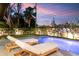 Inviting outdoor pool and lounge chairs for relaxing on a large patio, with lush landscaped backyard at 2177 Sunnyside Pl, Sarasota, FL 34239