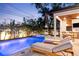 Relaxing backyard pool and spa with lounge chairs and outdoor kitchen, perfect for entertaining at 2177 Sunnyside Pl, Sarasota, FL 34239