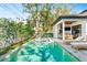 A sparkling pool and integrated spa are surrounded by lush landscaping, creating a private backyard oasis at 2177 Sunnyside Pl, Sarasota, FL 34239