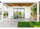 Covered porch with ceiling fan, stylish swing, and seamless indoor-outdoor living through sliding glass doors at 2177 Sunnyside Pl, Sarasota, FL 34239
