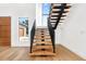 Modern staircase with wood treads, black railing, and an abundance of natural light at 2177 Sunnyside Pl, Sarasota, FL 34239