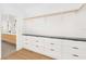 Modern walk-in closet featuring custom shelving, black hardware, granite countertop, and blonde wood flooring at 2177 Sunnyside Pl, Sarasota, FL 34239