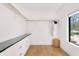 Spacious walk-in closet with custom shelving, black hardware, granite countertop and natural light from an outside window at 2177 Sunnyside Pl, Sarasota, FL 34239