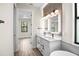 Elegant bathroom with double vanity, marble countertops, modern lighting, and wood tile flooring at 2375 Saybrook Ave, North Port, FL 34286