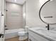 Bathroom featuring white vanity, marble countertop, shower-tub combo, and modern fixtures at 2375 Saybrook Ave, North Port, FL 34286