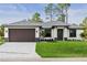 Charming single-story home featuring a well-maintained lawn, modern architectural details, and a two-car garage at 2375 Saybrook Ave, North Port, FL 34286