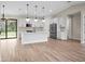 Open-concept kitchen with white cabinets, stainless steel appliances, a center island, and sliding glass door to yard at 2375 Saybrook Ave, North Port, FL 34286