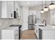An airy kitchen showcases stainless appliances, white cabinets and quartz countertops at 2375 Saybrook Ave, North Port, FL 34286