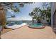 Beautiful brick patio with a pool, outdoor dining area, and bay views, creating a relaxing oasis at 2407 Avenue A, Bradenton Beach, FL 34217