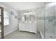 Gorgeous bathroom with a double vanity, marble tile, decorative lighting, and a glass-enclosed walk-in shower at 2407 Avenue A, Bradenton Beach, FL 34217