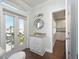 Bright bathroom featuring a granite vanity, modern lighting, and a door to the outdoor terrace with scenic views at 2407 Avenue A, Bradenton Beach, FL 34217