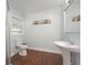 Bright bathroom featuring wood-look tile floors, a pedestal sink, and a decorative beach-themed accent at 2407 Avenue A, Bradenton Beach, FL 34217